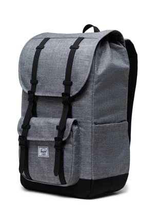 Grå stof rygsæk med rullelukning, sorte stropper og en frontlomme. Har en tekstureret overflade og forstærket bund.