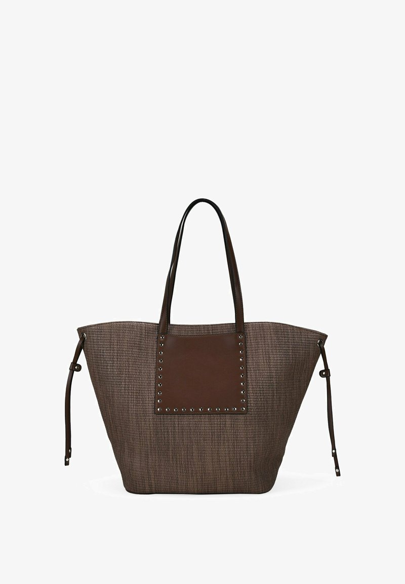 Bolso tote de gran tamaño en color marrón, con una tela texturizada de tejido y un panel de cuero liso en contraste que presenta tachuelas decorativas. Mangos largos y resistentes.