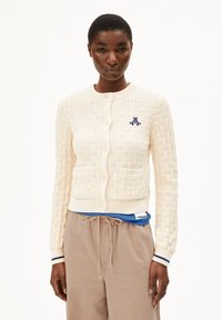 Cremefarbener gestrickter Cardigan mit einem strukturierten Muster, gerippten Bündchen und zwei Fronttaschen; mit blauen bestickten Logodetails.