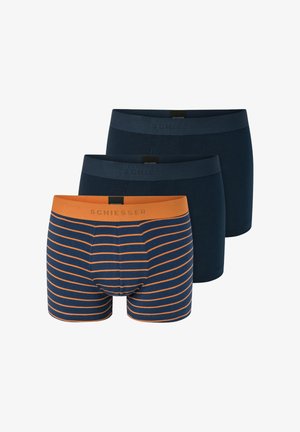 Tres pares de bóxers tipo slip. Dos de color azul oscuro uniforme con cinturillas elásticas; uno presenta rayas horizontales en azul marino y naranja con una cinturilla naranja.
