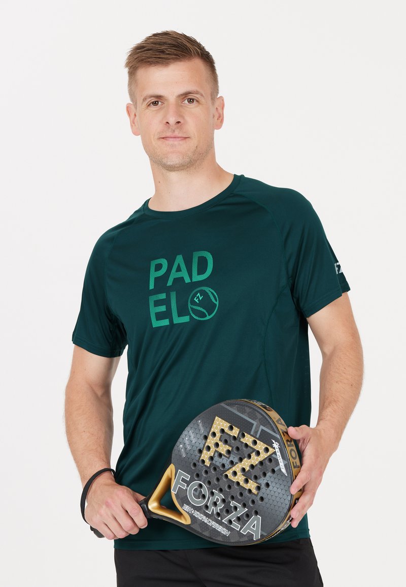 Mörkgrön sporttröja med "PADEL"-grafik, som bärs av en person som håller ett svart och guld padelracket med mönstrad yta och logotyp.