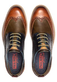Læderdressko med en blanding af mørkebrun, lys brun og olivengrøn. Detaljerede brogue-accents, kontrasterende snørebånd og tekstureret design.