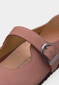 Ροζ δερμάτινο παπούτσι Mary Jane με ρυθμιζόμενο ασημένιο λουράκι με αγκράφα και επένδυση με μαξιλάρι στο εσωτερικό.