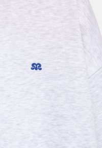 Felpa grigia realizzata in tessuto misto cotone, con un piccolo logo ricamato blu sul lato sinistro, texture liscia e design casual.