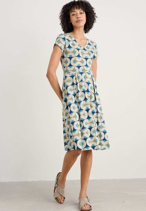 Robes à manches courtes en bleu, vert et crème avec un motif géométrique, décolleté en V et jupe évasée, fabriquées en tissu respirant.
