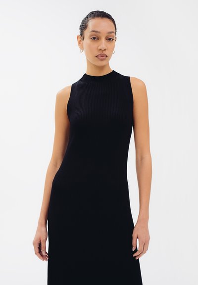 Schwarzes, geripptes Strickkleid mit hohem Kragen und ärmellosem Design. Es hat eine eng anliegende Silhouette und eine glatte Textur.