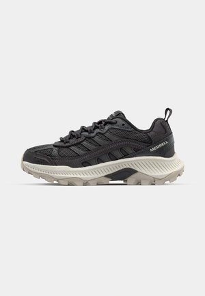 Scarpa sportiva nera con tomaia in rete traspirante, suola in gomma resistente e dettagli testurizzati, dotata di una linguetta sul tallone per indossarla facilmente.