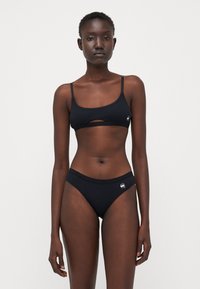 Fekete bikini szett puha anyagból. A melltartón kivágásos rész található, állítható pántokkal, míg az alsón komfortos derékpánt és logó díszítés van.