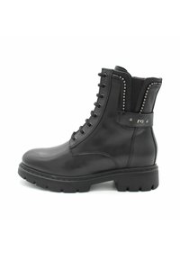 Botas de tobillo de cuero negro con punta redonda, diseño de cordones y tachuelas decorativas en el costado. Suela con un fuerte relieve para mayor tracción.