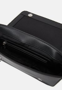 Borsa nera in pelle testurizzata, con chiusura zip e interno foderato dotato di una tasca con zip. Forma rettangolare compatta.