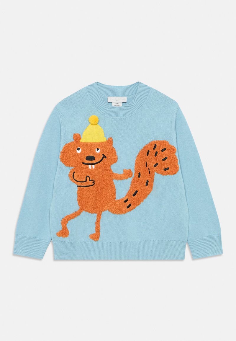 Világoskék kötött pulóver, amelyen egy textúrált narancssárga mókus dizájn látható, sárga kalappal és játékos arckifejezéssel, fekete díszítő vonalakkal a farkán.