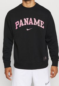 Felpa nera con la scritta "PANAME" in lettere rosa, logo Nike, colletto a girocollo, polsini e orlo con costine; realizzata in un morbido tessuto texturizzato.
