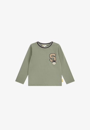 Lysegrøn børneskjorte med lange ærmer med sort og hvidt stribet krave, beige bogstav "S" og lille bjørn med hjelm på brystet.