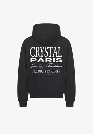 Zwarte hoodie met een grote witte grafische afbeelding op de achterkant, met de tekst "CRYSTAL PARIS," "Sieraden & Horloges," en "GEEN RIJKE OUDERS." Tekst in verschillende lettertypen op elkaar gestapeld.