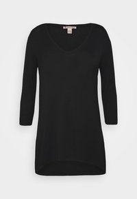 Svart långärmad topp med V-ringning, tillverkad av mjukt material. Har en avslappnad passform och rundad nederkant för ökad stil.