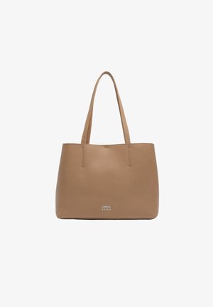 Kohvameha tan värvi tote-kott kahe käepidemega, ristkülikukujuline, sile tekstuur ja reljeefne logo alumises keskosas. Lihtsad disainidetailid.