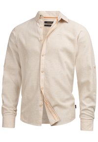 Chemise beige à manches longues avec détails de couture orange à l'intérieur de la patte de boutonnage et petit logo sur la poitrine, vue de face.