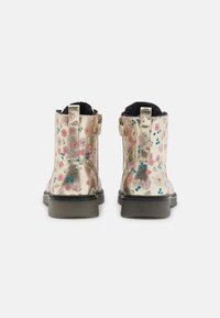 Bottes de cheville métalliques dorées avec un motif floral comprenant des fleurs roses, bleues et jaunes, une doublure noire et une semelle noire robuste.