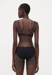 Black bra and matching underwear set, featuring a simple design with adjustable straps, a hook closure, and soft, smooth fabric.