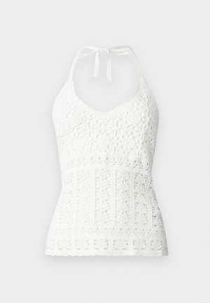 White crochet halter top with a v-neckline, featuring floral patterns and textured detailing throughout, finished with a tie at the neck.