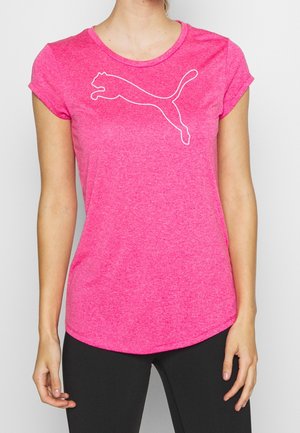 Vrouw draagt een felroze T-shirt met korte mouwen met een wit springend puma-logo op de borst en zwarte legging.