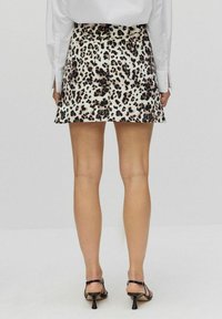 Sæt med leopardmønstret nederdel i en svungen design, lavet af letvægtsstof, med høj talje og to baglommer.