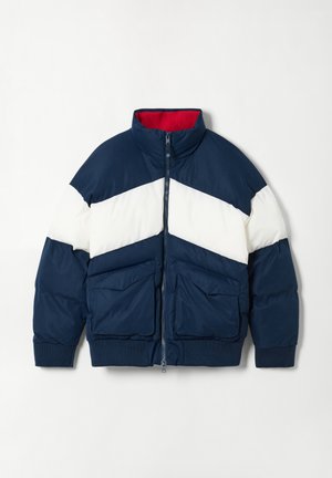Gevoerde jas met hoge kraag, blauwe body, wit en marineblauwe kleurblokontwerp en twee voorzakken. Rode voering.