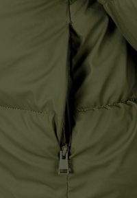 Groene pufferjack met een gesloten ritssluiting. Glad materiaal met een licht glanzende afwerking. Gestikt naad zichtbaar langs de randen.