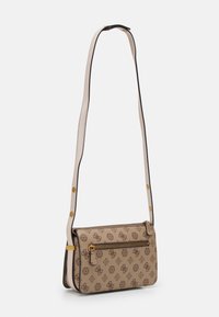 Béžová kabelka přes rameno s tmavě hnědým vzorem loga, zlatými zipy a nastavitelným popruhem. Má přední zipovou kapsu a strukturovaný design.