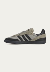 Gray and black athletic shoes with a suede and textile upper, featuring three black stripes and a textured rubber outsole.