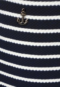 Navy blue striped fabric with horizontal white stripes, featuring a metallic anchor emblem as a notable detail.