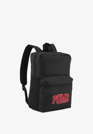 Sac à dos Puma noir avec bretelles rembourrées, poche avant zippée, poches latérales en mesh et logo Puma rouge sur la poche avant.