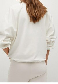 Witte, losse blouse met een ronde halslijn en pofmouwen. Het gladde materiaal en de elastische tailleband zorgen voor een ontspannen silhout. 