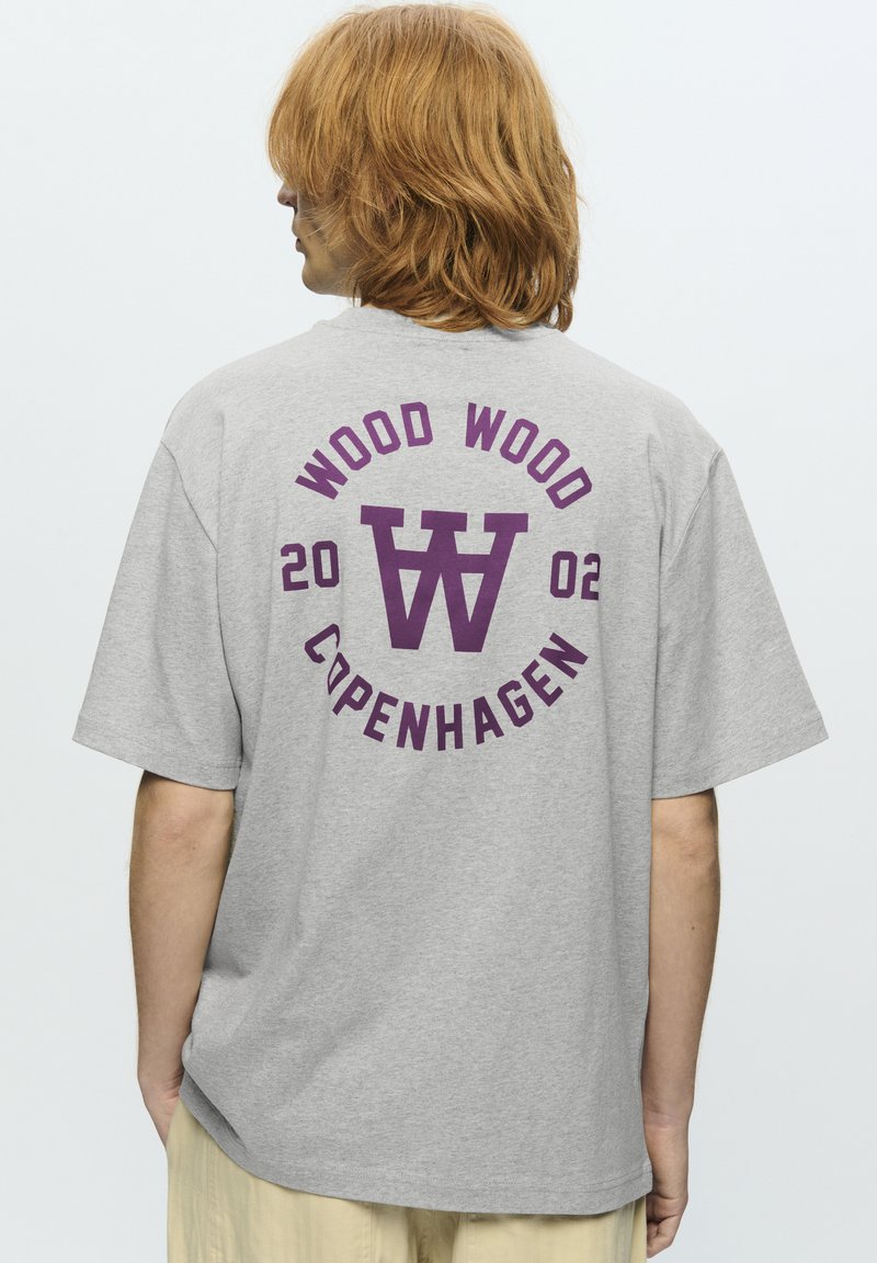 Grå bomulds t-shirt med korte ærmer, udstyret med et stort lilla grafik med "WOOD WOOD," "COPENHAGEN," og "2002" på ryggen.