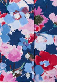 Bloemenschirt met een marineblauwe achtergrond, voorzien van grote roze, rode en blauwe bloemen, en witte plastic knopen aan de voorkant.