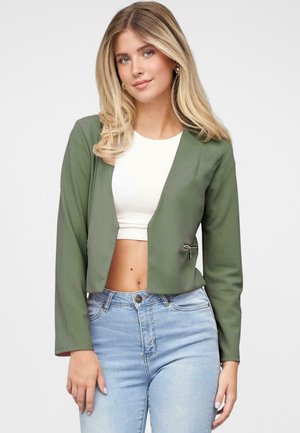 Ingekorte groene jas van zachte stof met lange mouwen, voorzien van een haaksluiting aan de voorkant, gecombineerd met een witte top en lichtblauwe jeans.