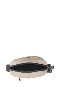Marsupio in beige e nero, realizzato in materiale morbido, con chiusura a zip e una superficie testurizzata con cuciture visibili.