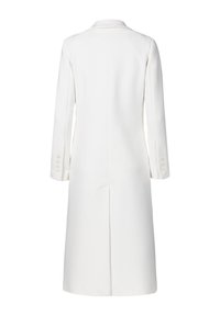 Manteau long blanc avec une finition texturée, col à revers et manches longues avec des accents de boutons. Couture centrale et détail d'une fente dans le dos.