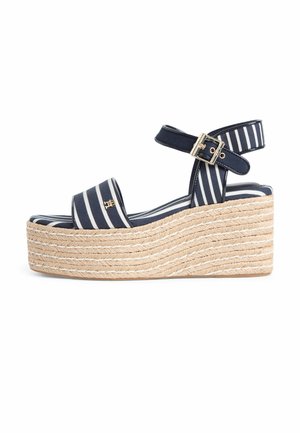 Marineblaue und weiße Sandale mit Keilabsatz, Riemchen am Knöchel, goldener Schnalle und gewebter Seilsohle.
