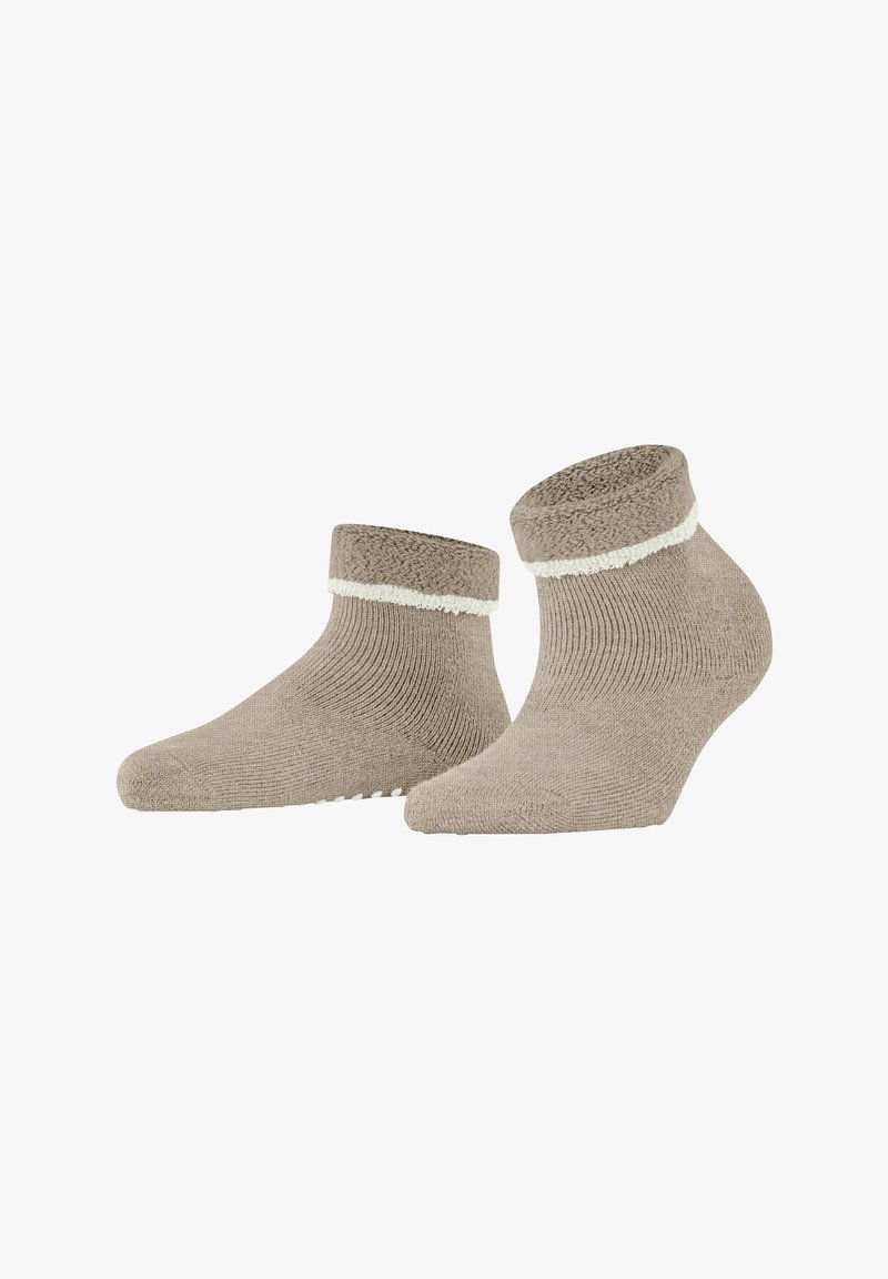 Miękkie beżowe skarpetki do kostek z podwiniętą mankietą, ozdobione białym wykończeniem i z antypoślizgowymi wstawkami na podeszwie, na białym tle.