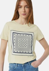 Lichtgele t-shirt met een marineblauw geometrisch patroon in het midden, ronde halslijn, korte mouwen en een ontspannen pasvorm.