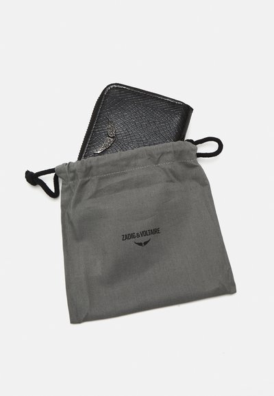 Black leather wallet with a textured finish partially visible inside a gray drawstring pouch, featuring the brand name printed in black.