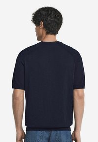 Marinblå kortärmad stickad skjorta, lätt tyg, ribbad rund halsringning, ren design, avslappnad passform, med raglanärmar och utan synliga logotyper.