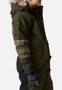 Green waterproof snowsuit with a fur-lined hood, side pockets, and black accents. Includes gray gloves with adjustable straps and grip.