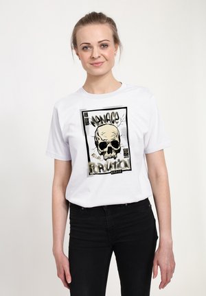 T-shirt blanche avec un imprimé graphique d'un crâne avec des accents noirs et dorés, entouré de texte, sur un tissu en coton lisse.