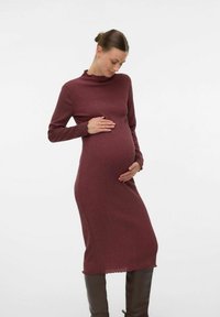 Robe de maternité en tissu côtelé bordeaux avec des manches longues et un col haut. Présente une silhouette ajustée et un ourlet festonné.