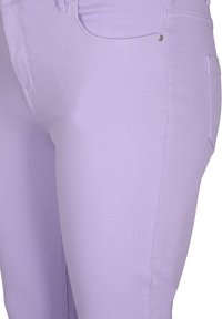 Laventelinväriset farkut, joissa on sileä rakenne, etutasku ja hopeinen napitus vyötäröllä.