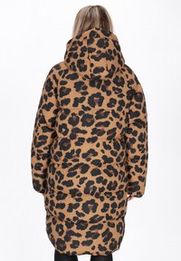 Brun leopardmønstret pufferjakke med hætte, med en kviltet design og elastiske manchetter. Jakken er knælængde med en afslappet pasform.
