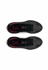 Chaussures de sport noires avec un dessus texturé, des accents rouges et un panneau en mesh. Présente un logo et un design épuré pour la performance.