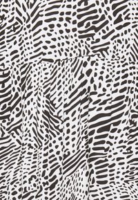 Black and white patterned fabric with abstract, wavy lines and dots. The texture is smooth, featuring pleats along the bottom edge.